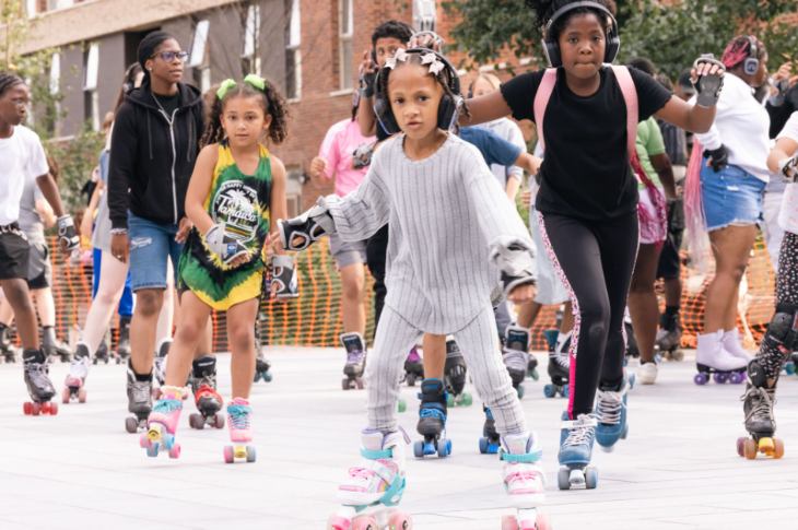 Children wearing headphones and roller skating