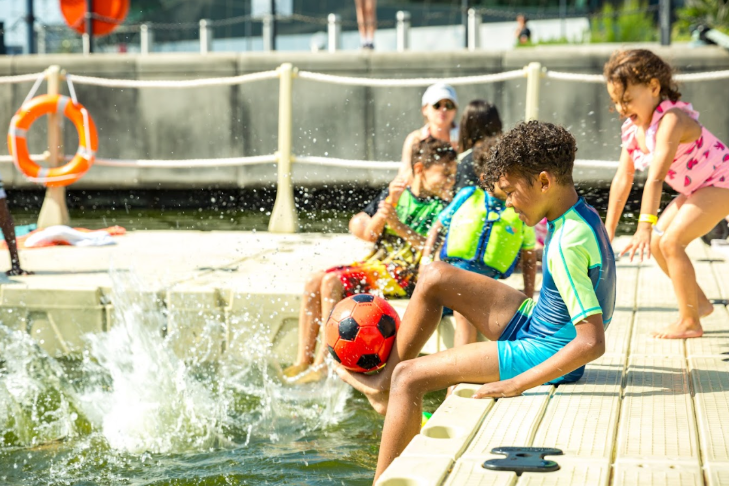 Beaches in London summer 2025: children sitting on the edge of a pool, splashing with their feet