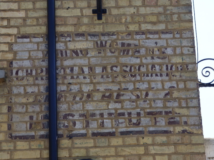 Visit Sevenoaks: a ghost sign on a pale brick wall