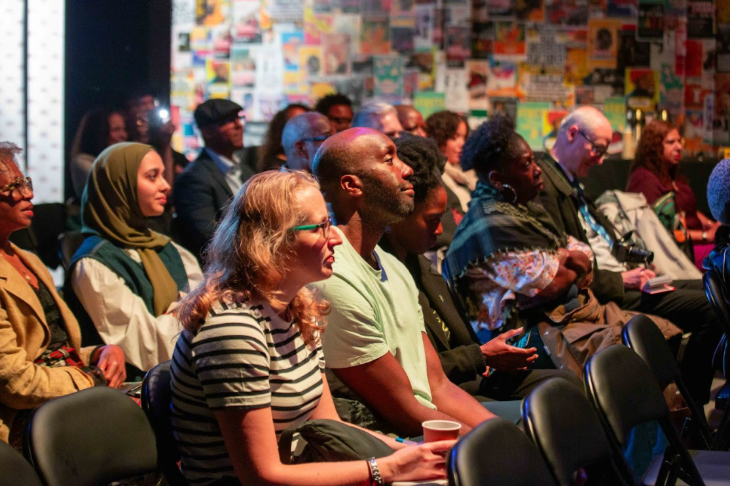An audience looking towards the front of a room