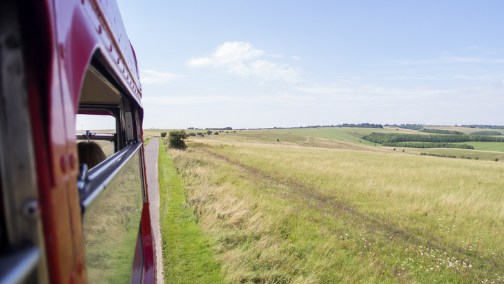 A bus driving over open countryside