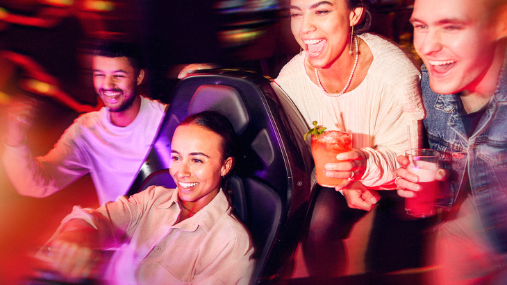 People playing on a racing arcade game