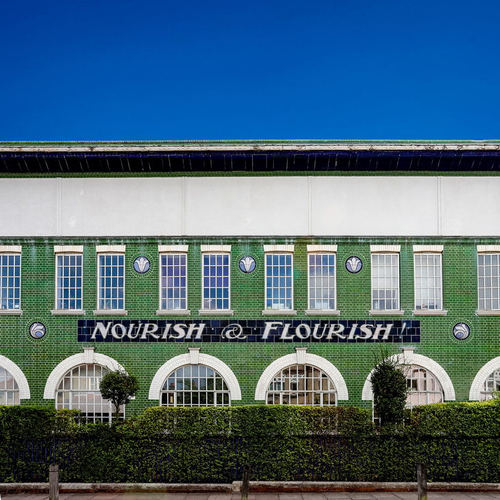 An old factory with 'Nourish, Flourish' on it