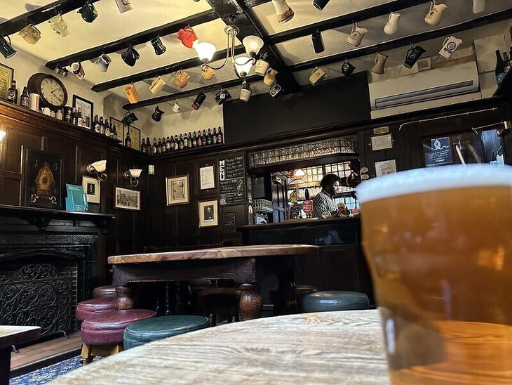 A pint in the pub, with loads of jugs hanging from the ceiling