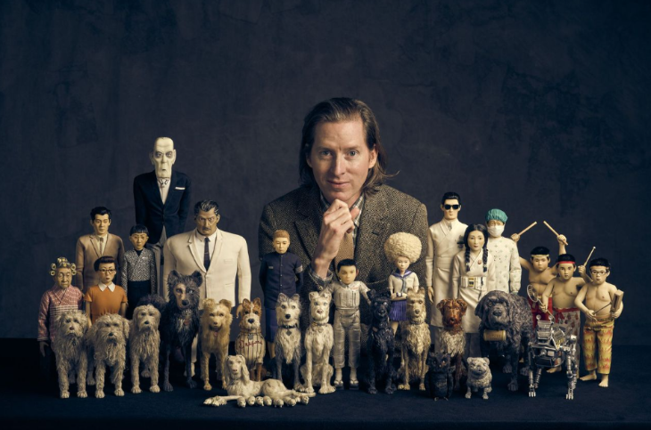 Things to do in London this autumn 2025: Wes Anderson posing for a photo behind models from Isle of Dogs