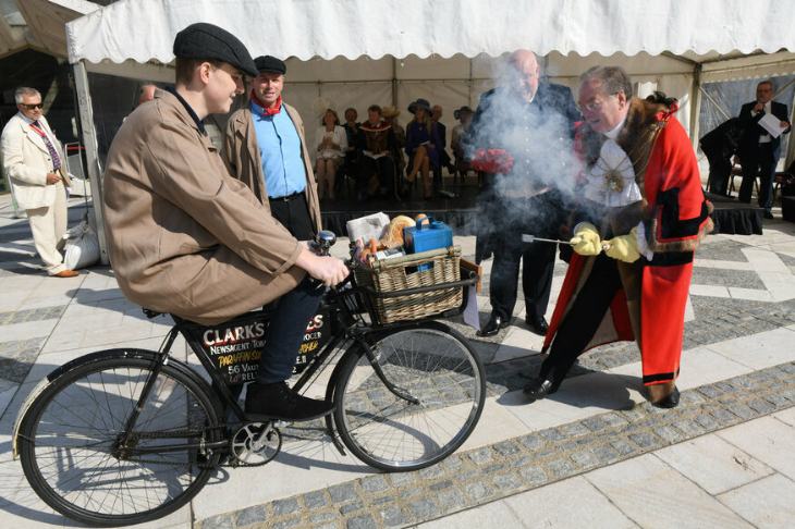A man riding a bicycle while it's branded with a hot poker