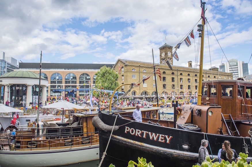 A wooden sail boat, one of several boat moored up at St Katharine Docks