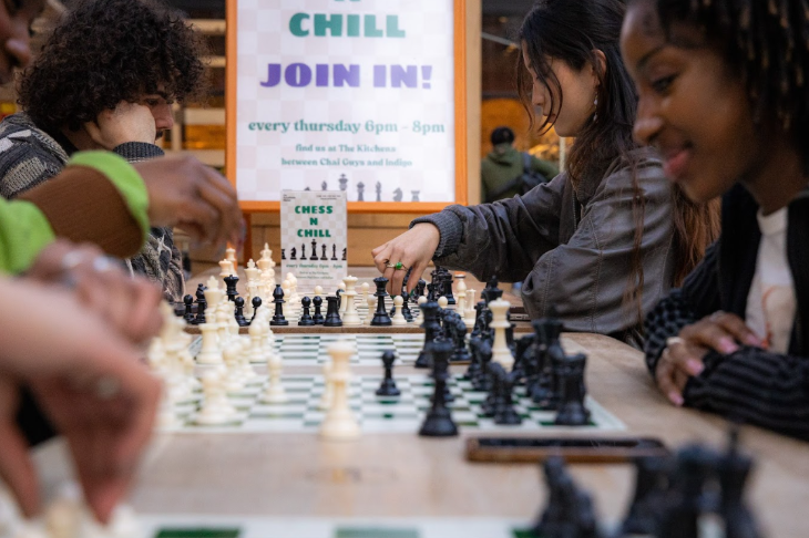 People sitting around tables playing chess
