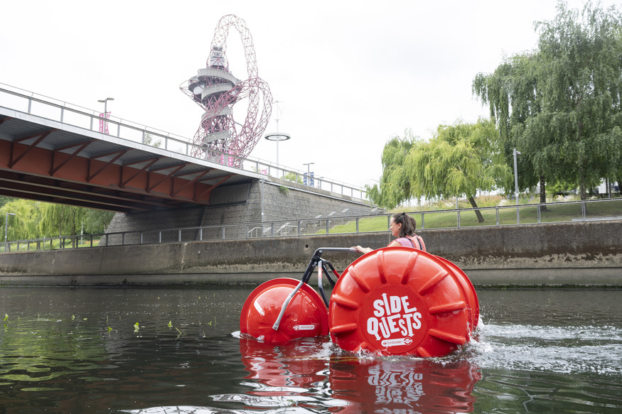 Someone pedalling a water bike past the Arcelormittal Orbit
