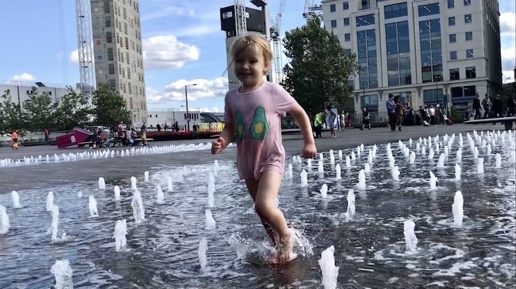 Play fountains in London: a little girl running through jets of water in Granary Square