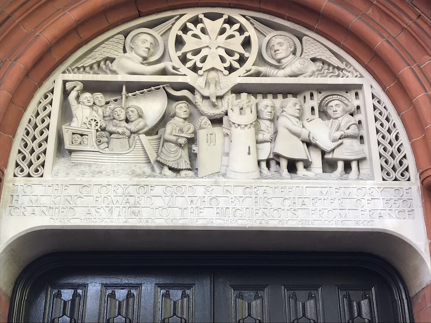 Stone carving of huguenots arriving in england and greeted by Edward Vi