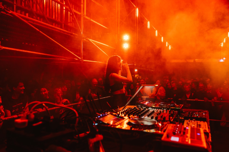 Things to do in London August 2025: a DJ at DJ decks in a smoky, red-lit room