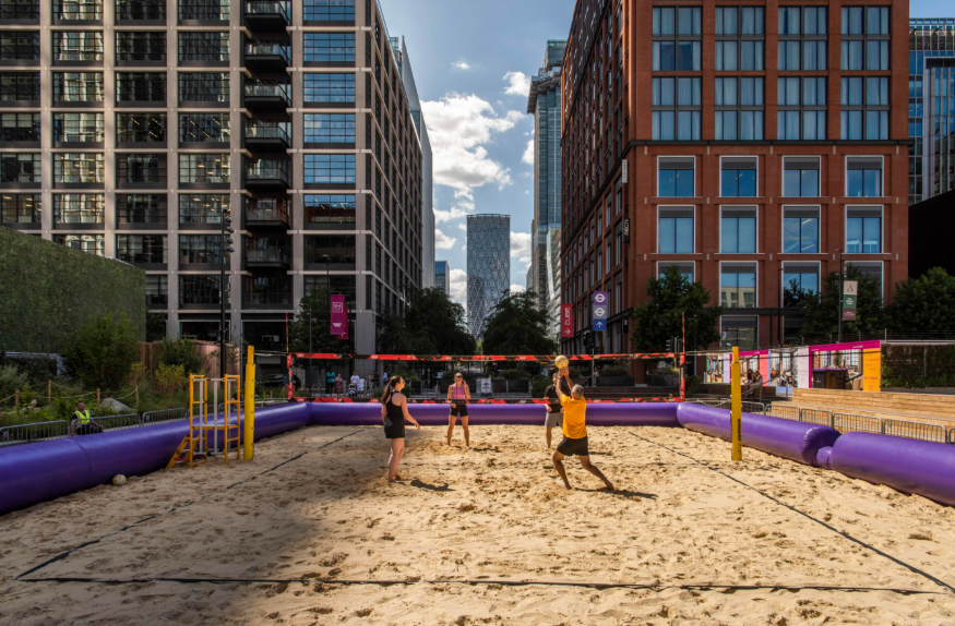 Things to do today in London:  people playing volleyball on an outdoor sand court in Canary Wharf