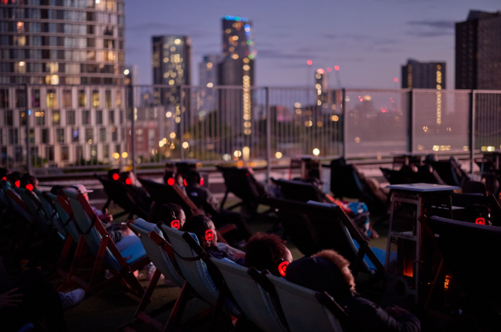 Things to do today in London: people sitting in deckchairs on a rooftop at dusk, watching a film