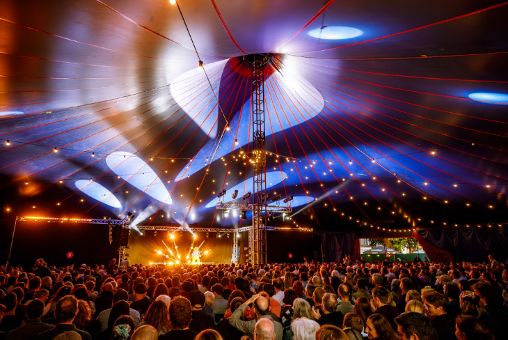 Things to do in London this autumn 2025: crowds of people watching a show inside a big top tent