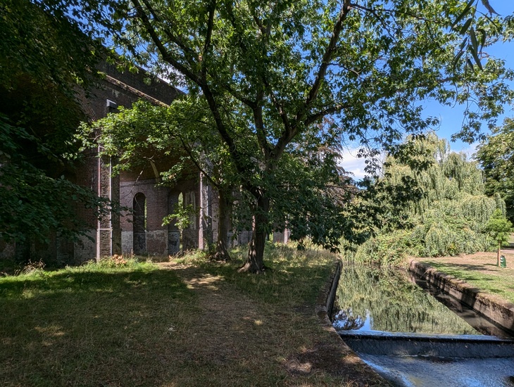 A verdant park with the viaduct in shot