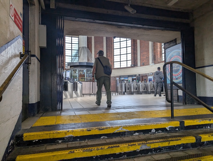 A man ascending the steps into the ticket hall