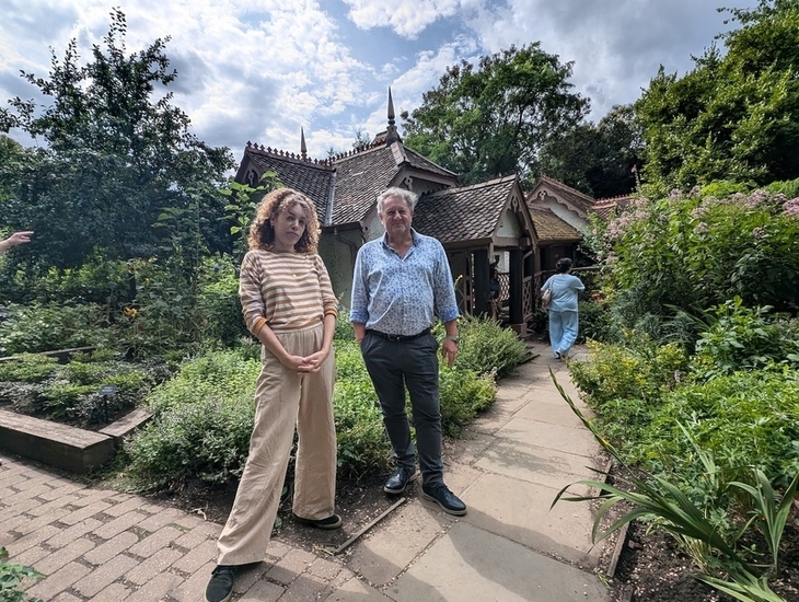 Two people standing outside a quaint cottage