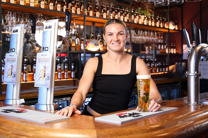 Ellie Kildunne serves a pint of Asahi at the Asahi Open Arms