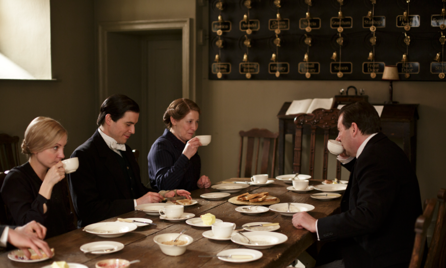 Free events in London: Downton Abbey servants sitting around a table, with the bell wall in the background