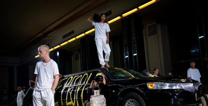 Things to do in London today:  A dancer holding a boombox standing on top of a grafittied Limo, with others surrounding the car