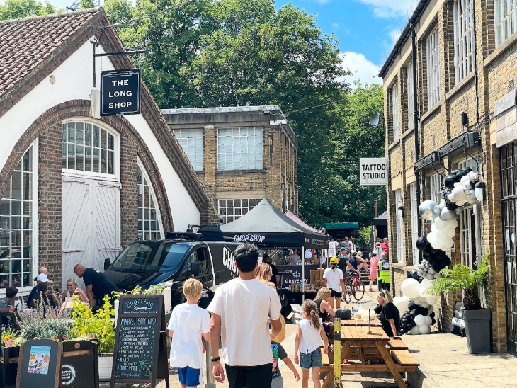 Events in London this weekend: people walking down an alleyway with shops on either side and market stalls in the middle