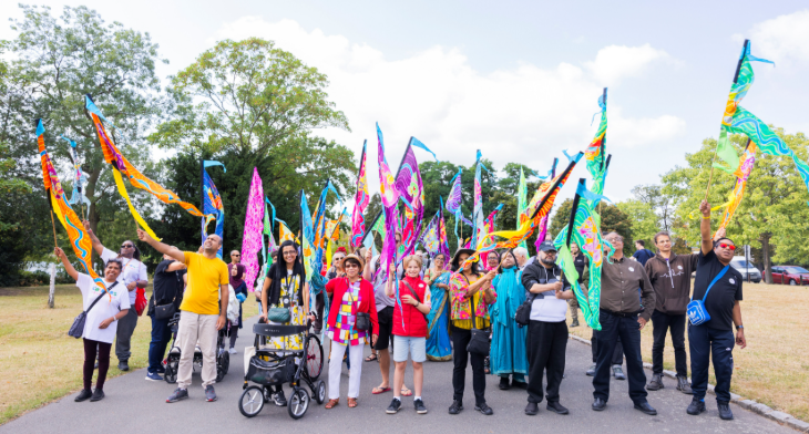 Things to do in London this weekend: People waving colourful flags as they parade through a park