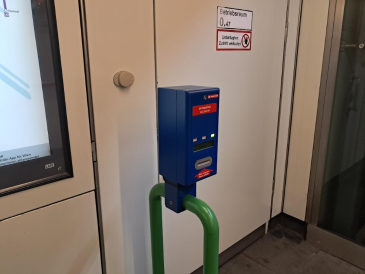 A blue validator machine mounted on a green pole