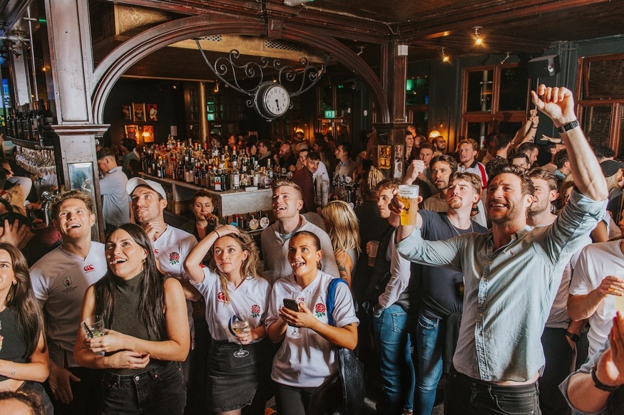 People cheering on England in the pub