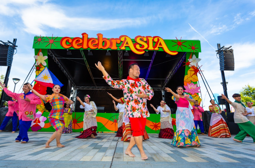 What's on in London this weekend: people taking part in a choreographed dance in colourful costumes in front of a 'CelebrASIA' sign