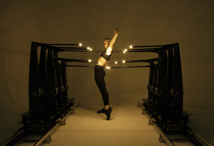 A woman striking a pose in a strange art exhibit with lights