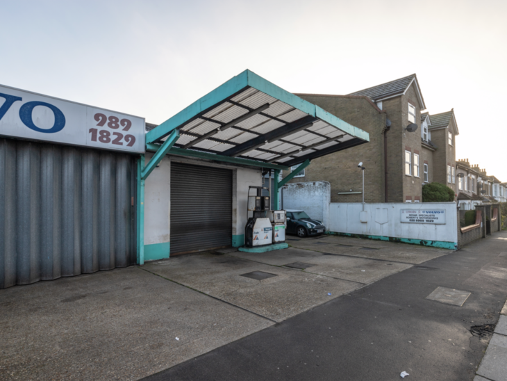 A disused garage with turquoise canopy