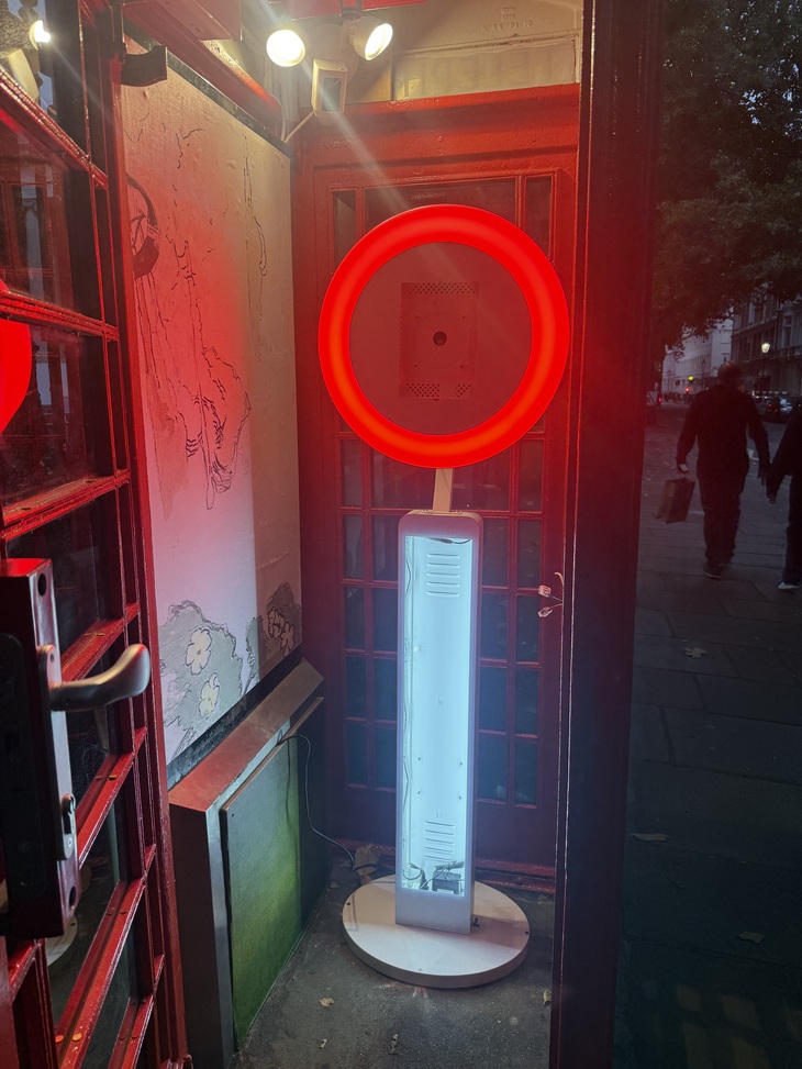A bright red illuminated ring in a phone box