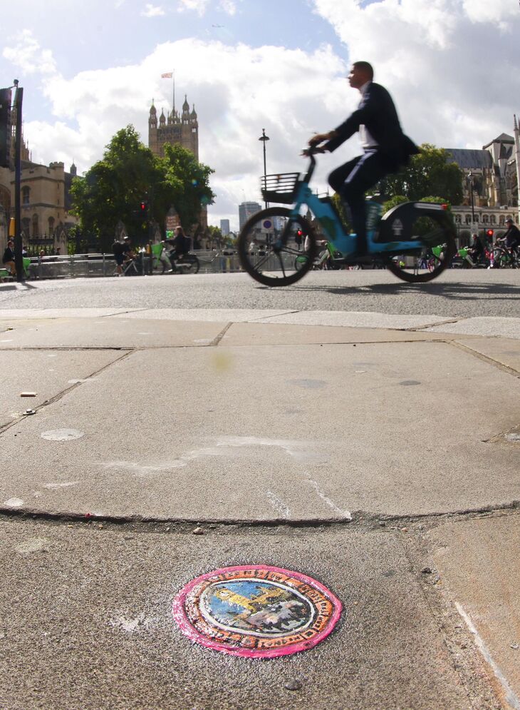 A cyclists passing an artwork