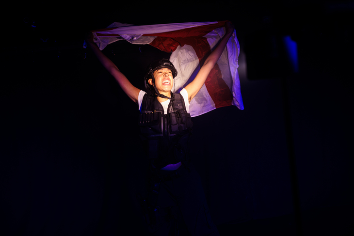 A person in riot gear holding an England flag