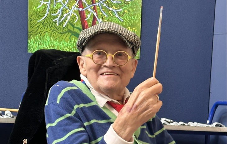 David Hockney holding a brush