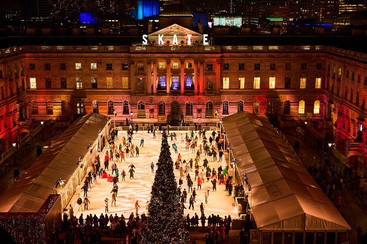 Christmas 2025 ice rinks in London: people skating on an ice rink in the courtyard at Somerset House, in front of a large Christmas tree