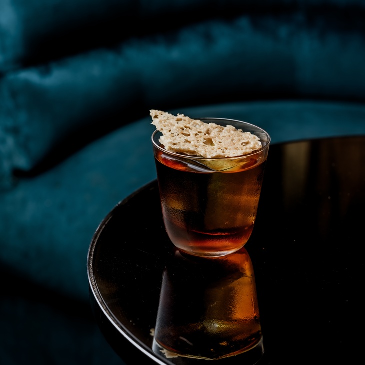 London Cocktail Week: A dark cocktail with what looks like honeycomb perched on top