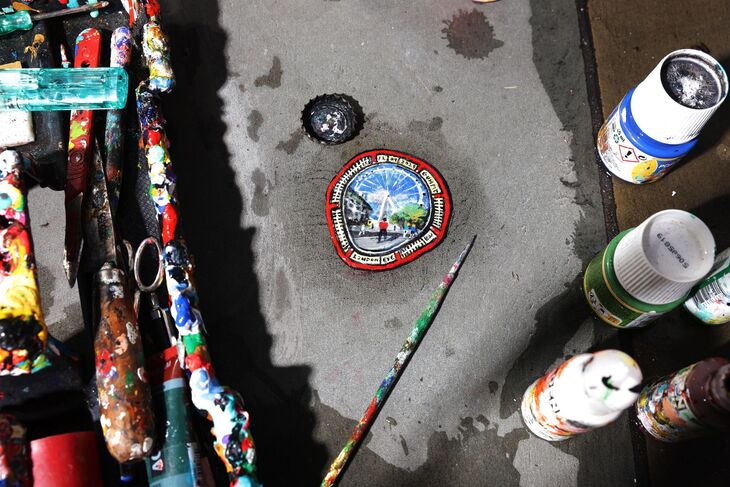 A painting of the Eye surrounded by paint and brushes