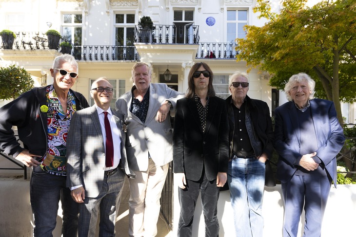 A group of rock stars in front of the house