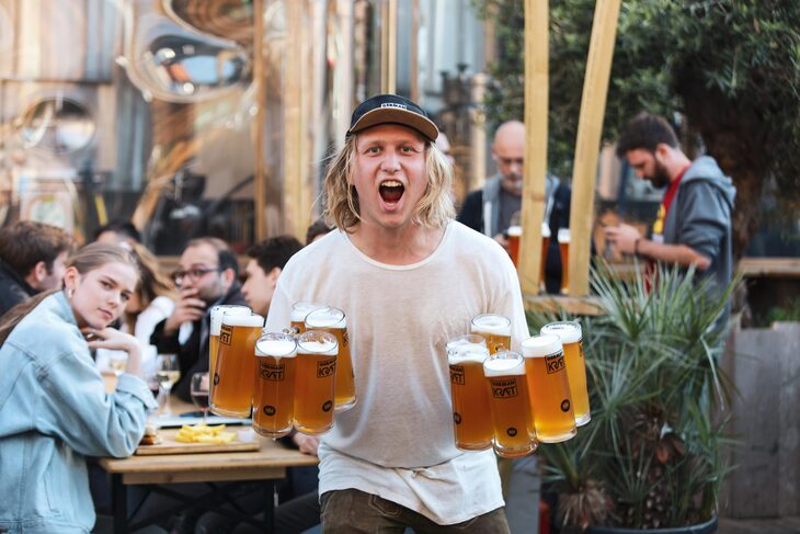 A guy holding multiple beers