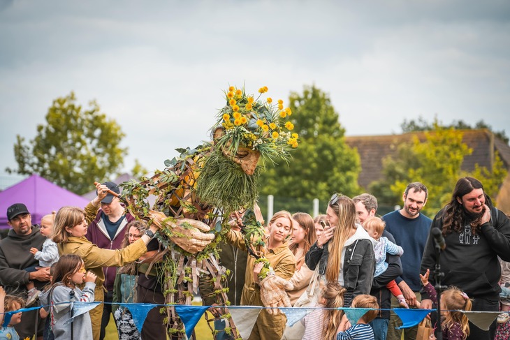 People with a large puppet of a garlanded figure