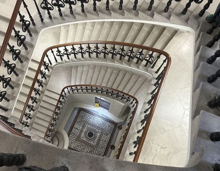 A staircase with a mosaic at the bottom
