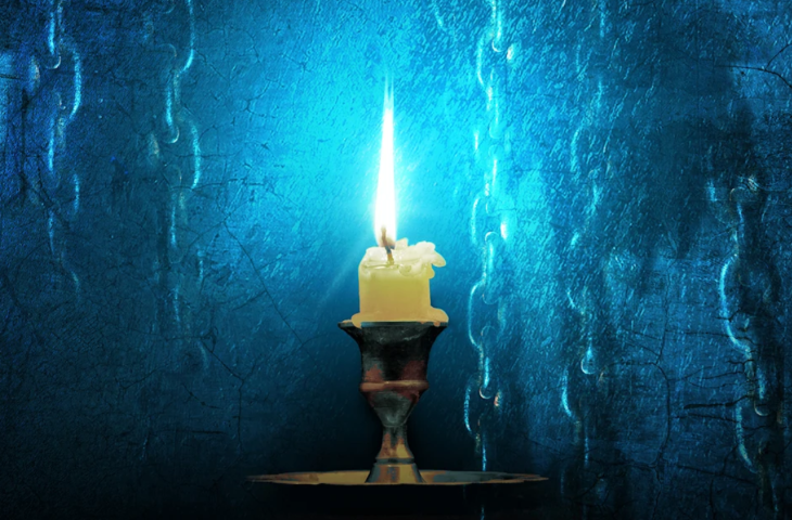 Christmas 2025 shows London: a candle in a traditional metal candle holder, almost melted right down to the wick