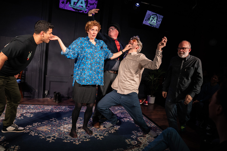 People in the middle of improv - two men being held by their mouths