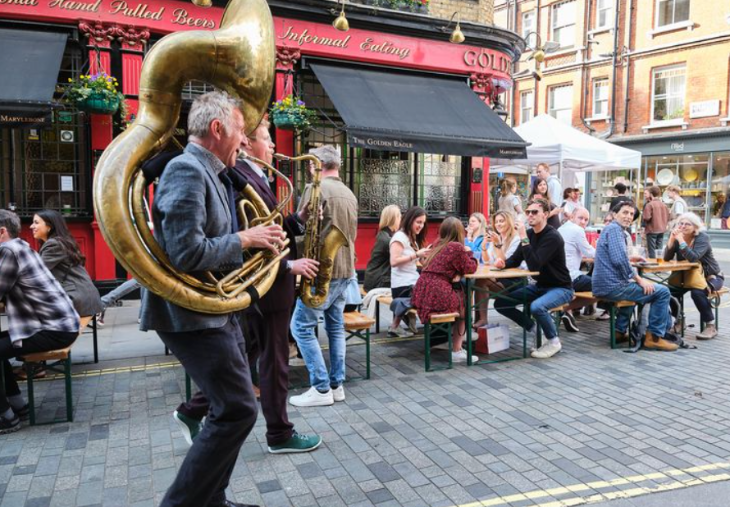 Free things to do in London:  a brass band walking down a road