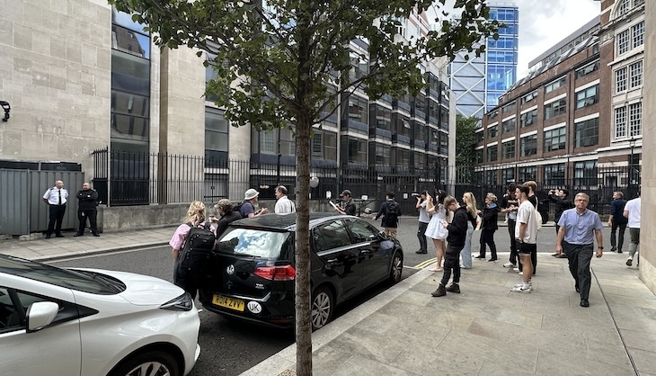 A crowd photographing two security guards