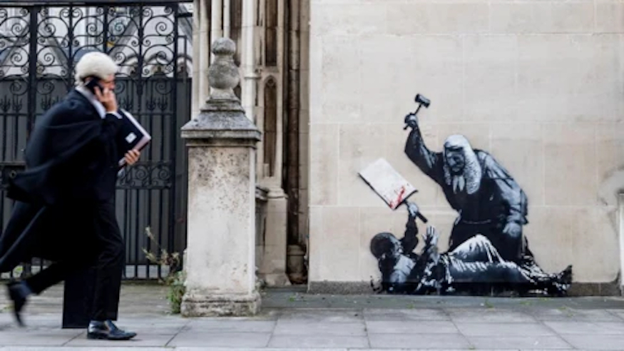 Banksy stencil of a judge hammering a protestor