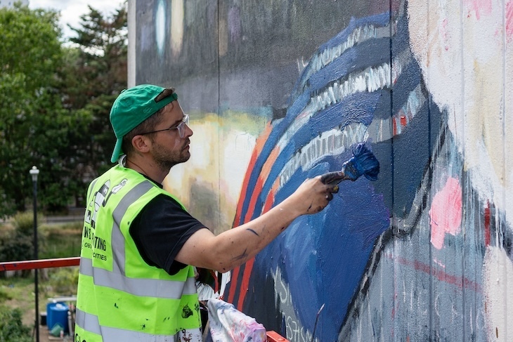 Sebas Velasco painting a mural