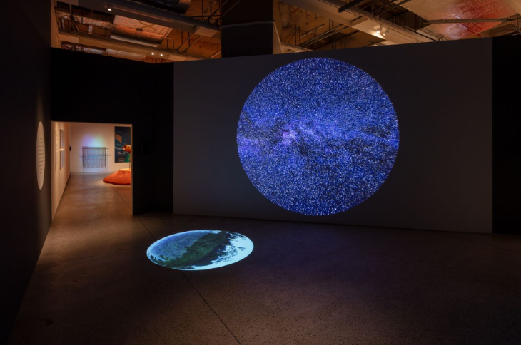 Things to do in London in October 2025: a projection of a planet onto the wall of a gallery,  reflected onto the floor